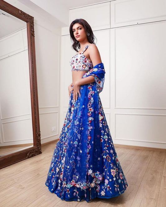 Demanding Net Embellished Blue Color Lehenga Choli